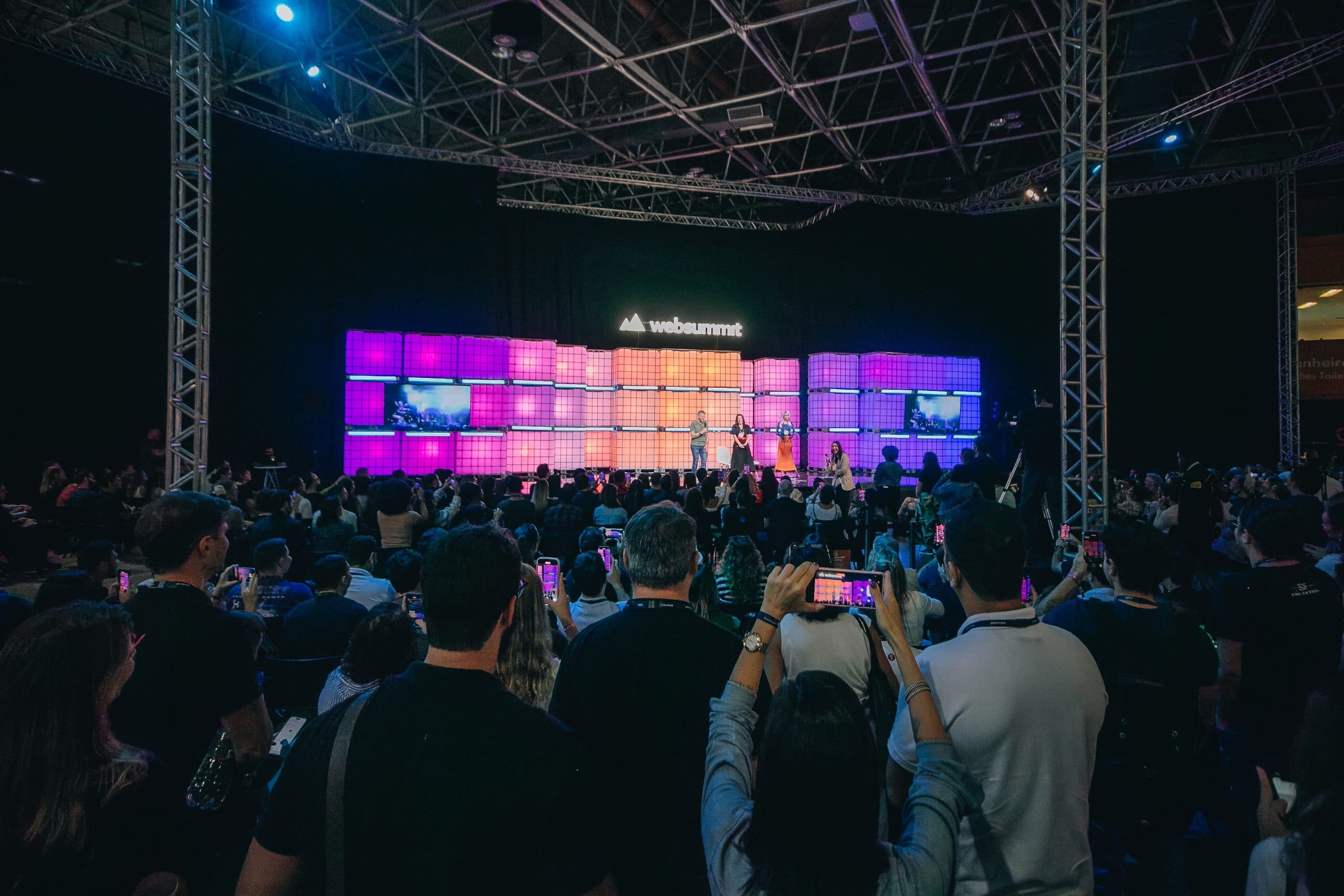 Arena escura com palco iluminado e público
