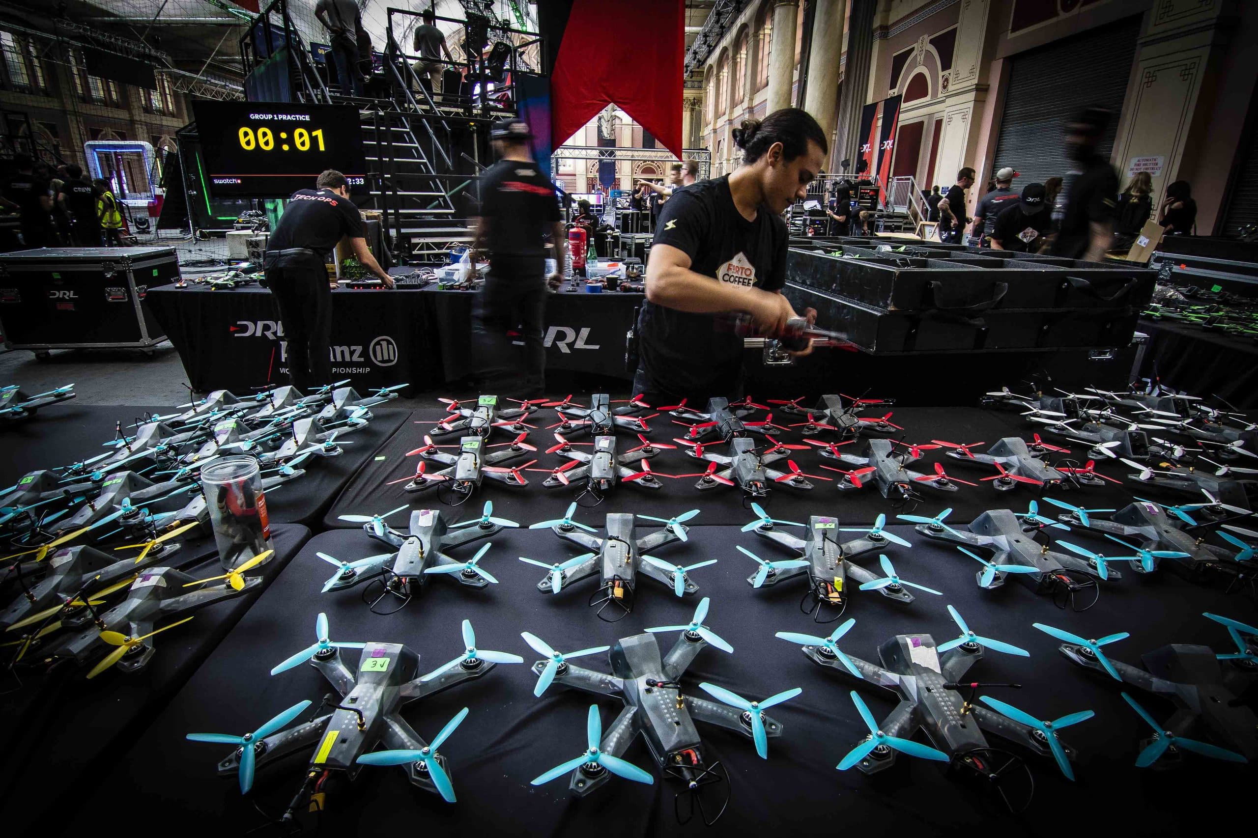 Bancada de drones de corrida sendo preparados