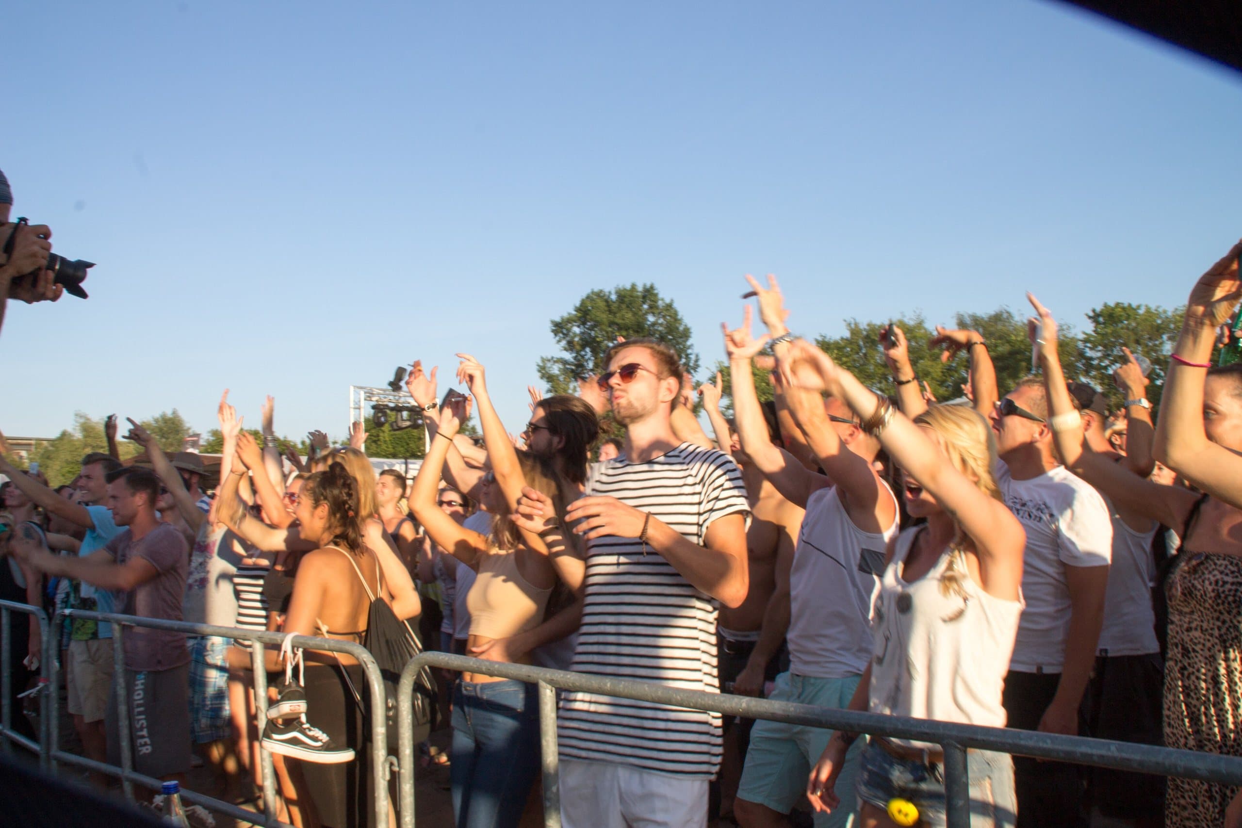 Público feliz com os braços para cima em festival ao ar livre